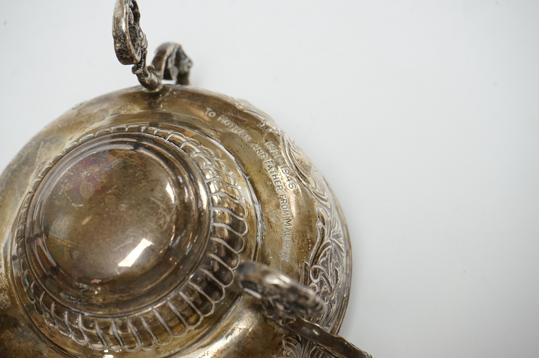 A late Victorian embossed silver bowl, on tripod supports, London, 1890, lacking glass insert?, diameter 12.2cm, together with a Middle Eastern white metal candlestick and a modern silver tumbler cup. Condition - fair to